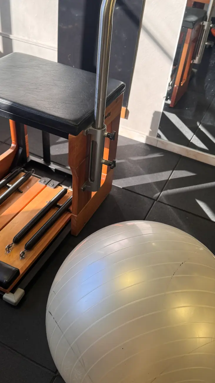 Aparelho de Pilates e bola de estabilidade sob luz natural