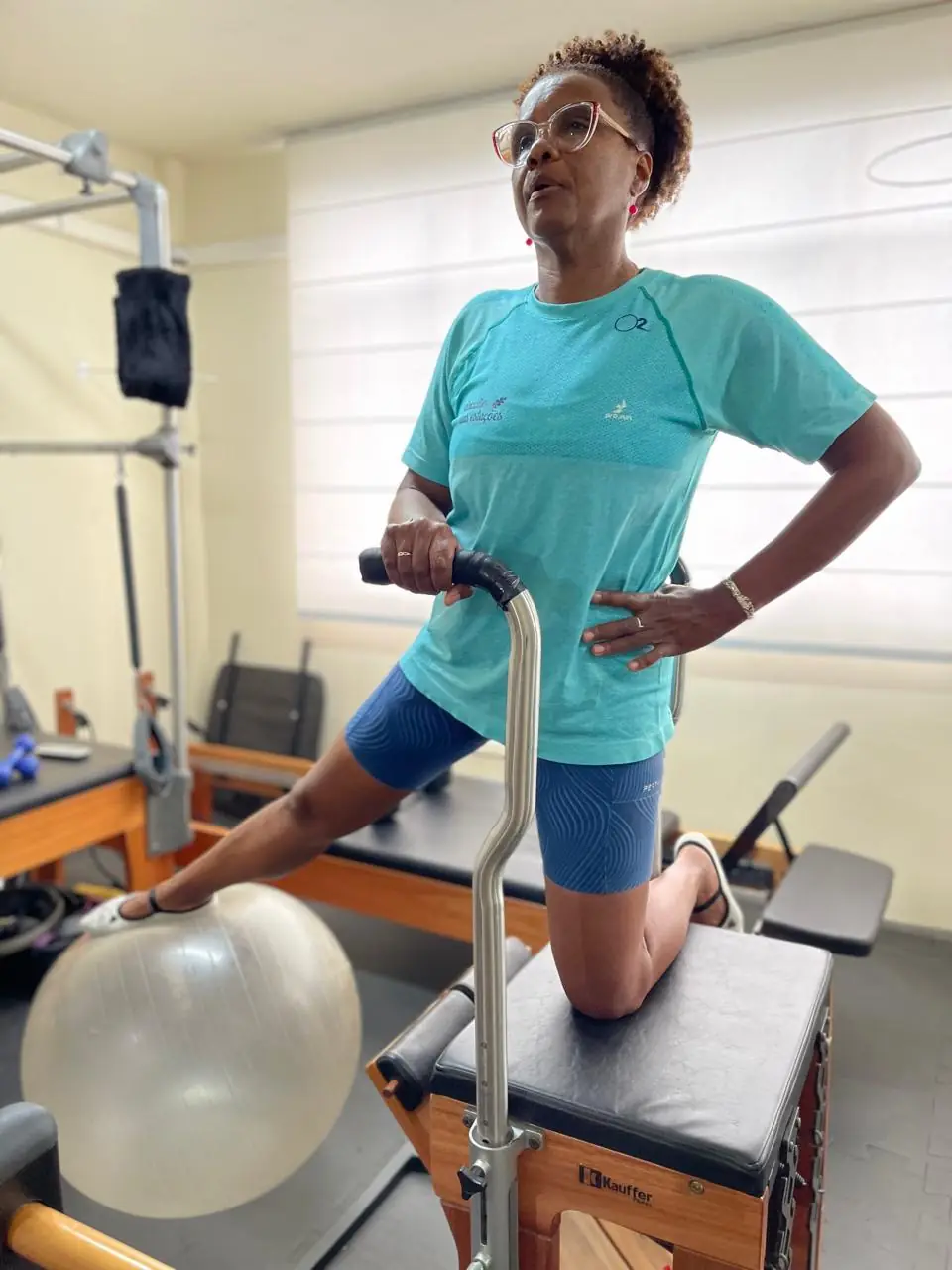 Aluna em exercício de equilíbrio com apoio de barra no Revita Studio